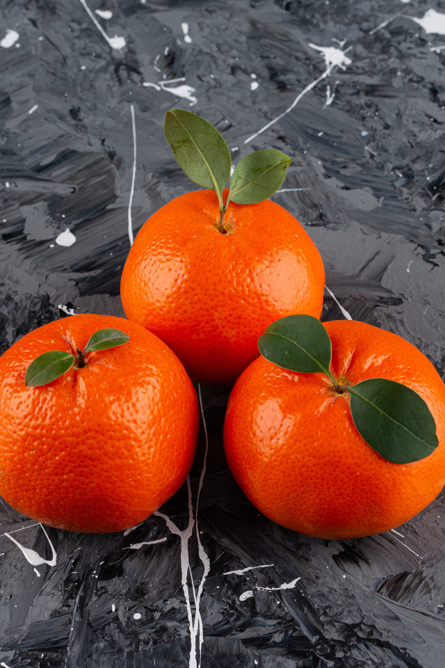 Три мандарина на сером столе