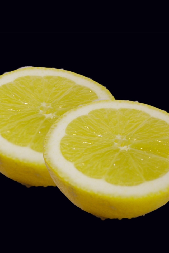 Две половинки лимона на черном фоне