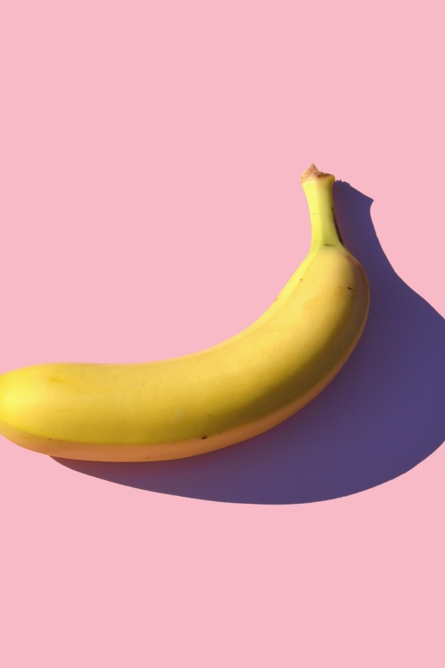 Желтый банан на розовом фоне