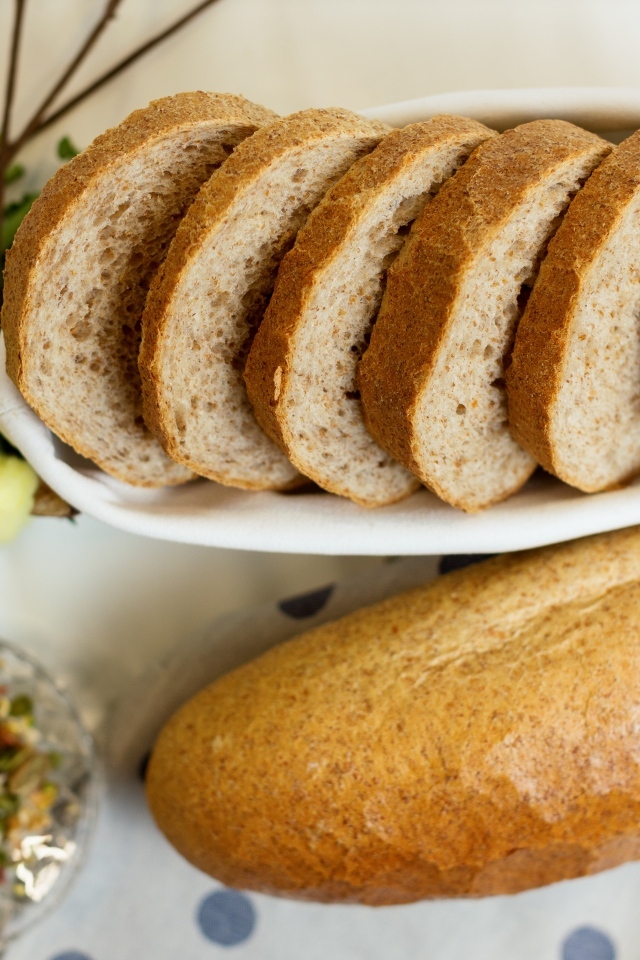 Батон нарезанный на столе с цветами