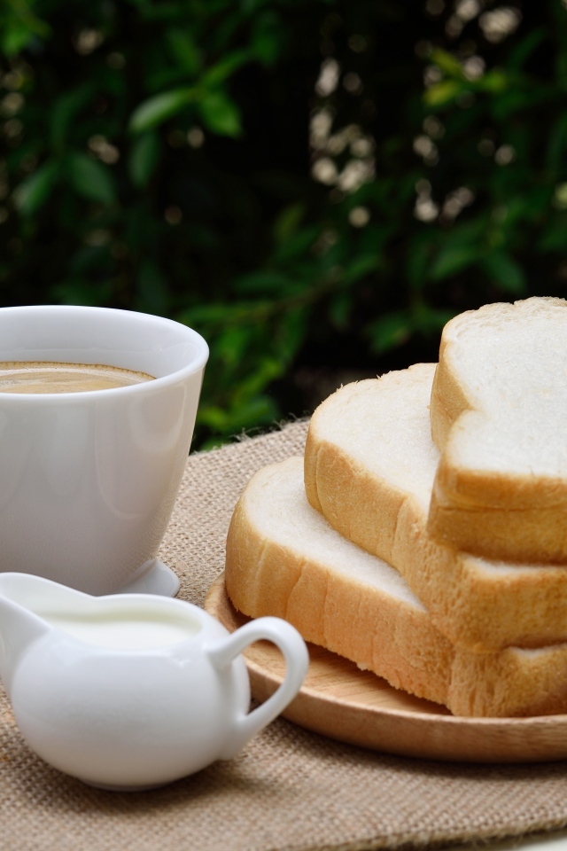 Хлеб на столе с кофе и молоком