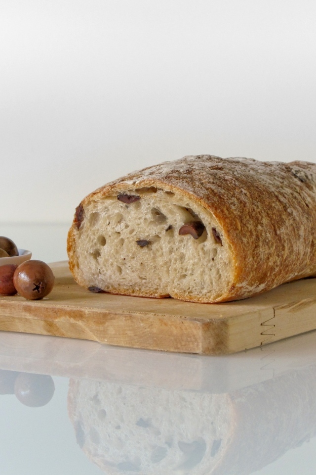 Свежий хлеб с оливками на разделочной доске