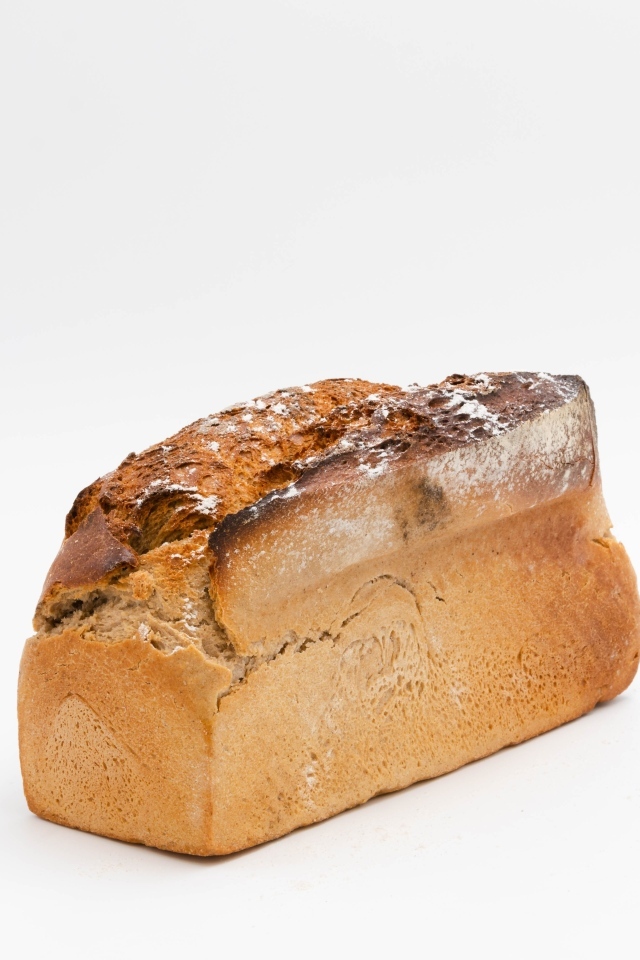 Буханка свежего хлеба на белом фоне