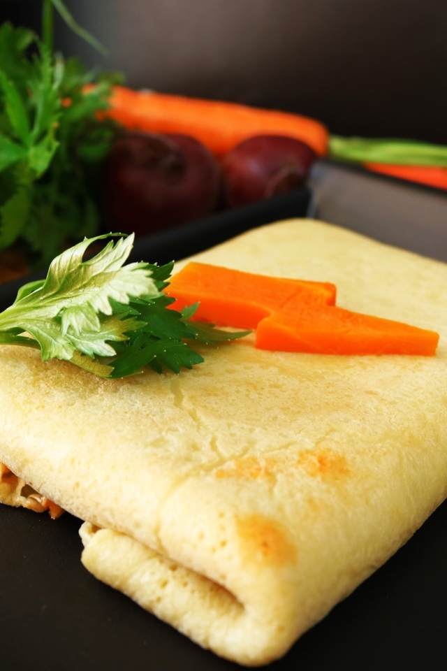 Блинчик на тарелке с морковью и веточками петрушки