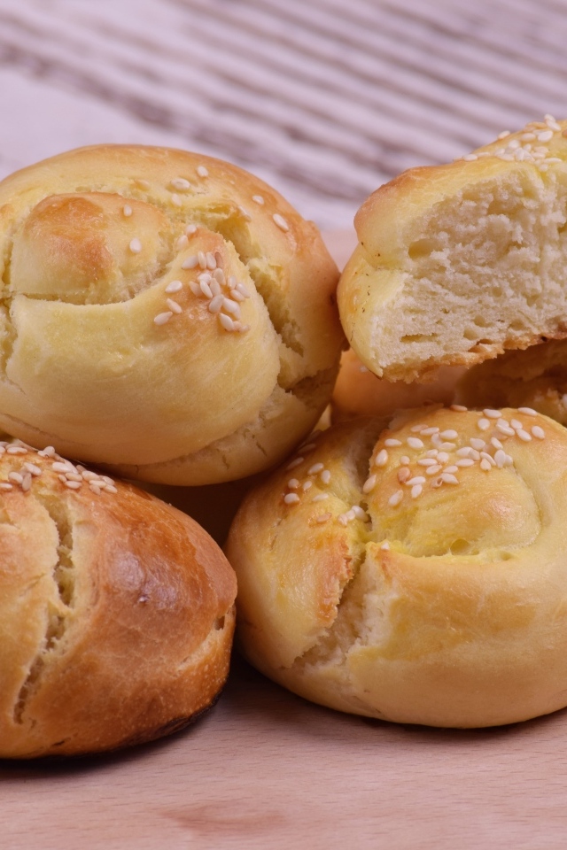 Аппетитные сладкие булочки с кунжутом на столе