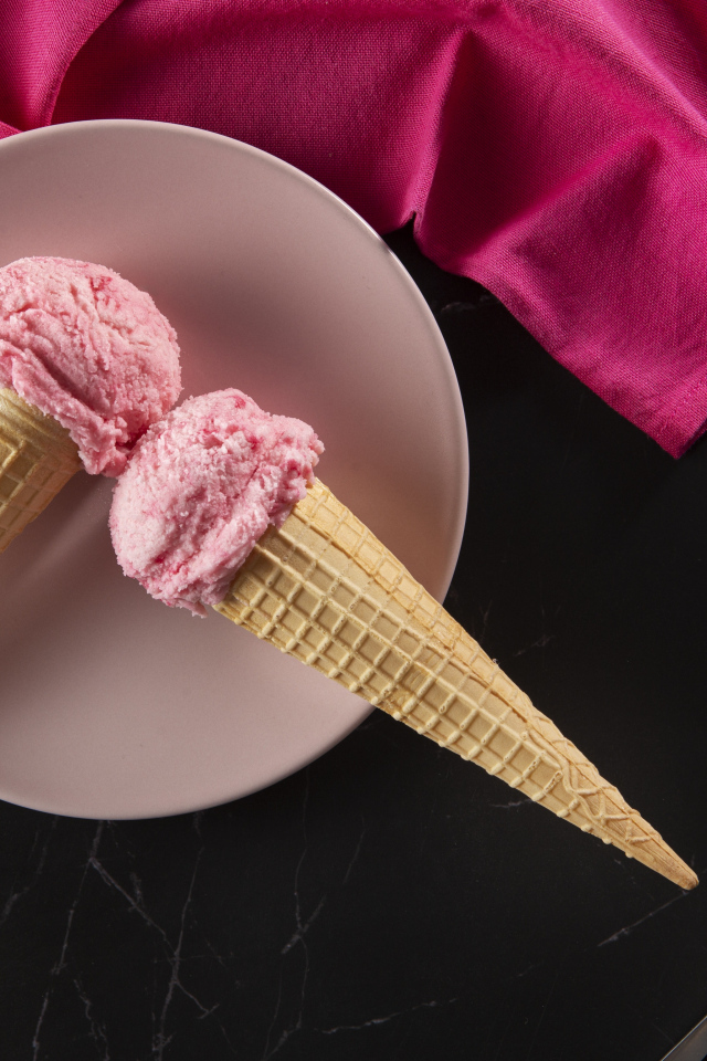 Ягодное мороженое в вафельных рожках на столе