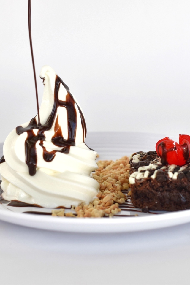 Пирожное со взбитыми сливками на тарелке на белом фоне