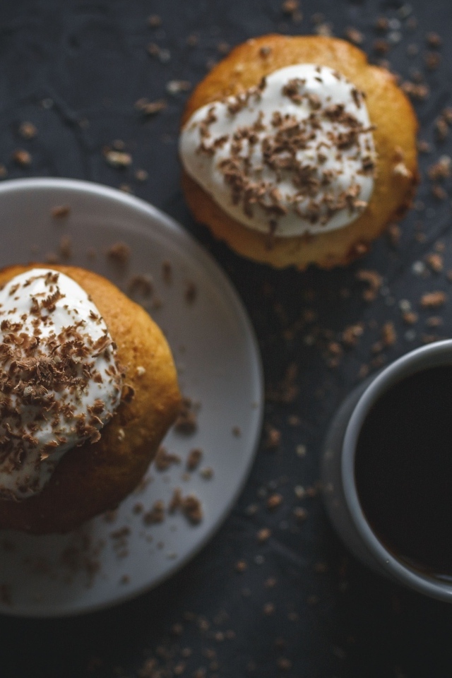 Пирожное в тертым шоколадом на столе с чашкой кофе