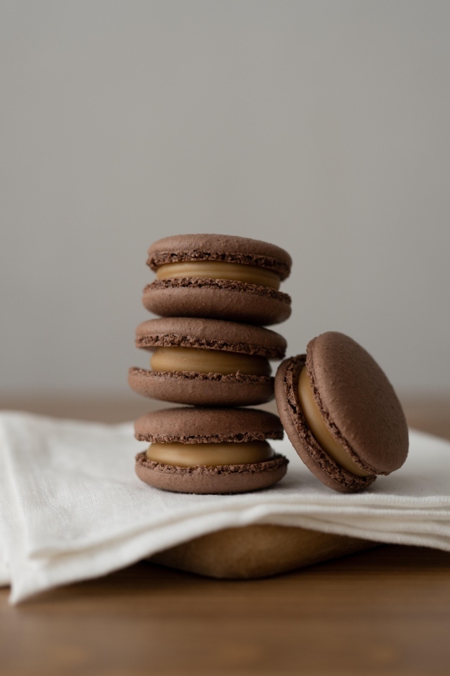 Шоколадный десерт макаронс на столе с салфеткой