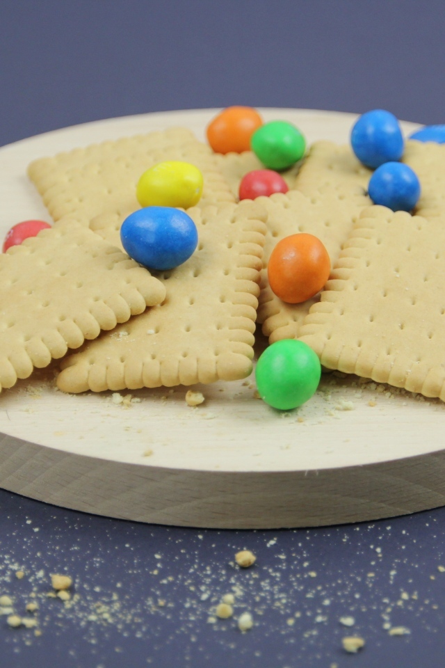 Печенье с разноцветными конфетами на сером фоне