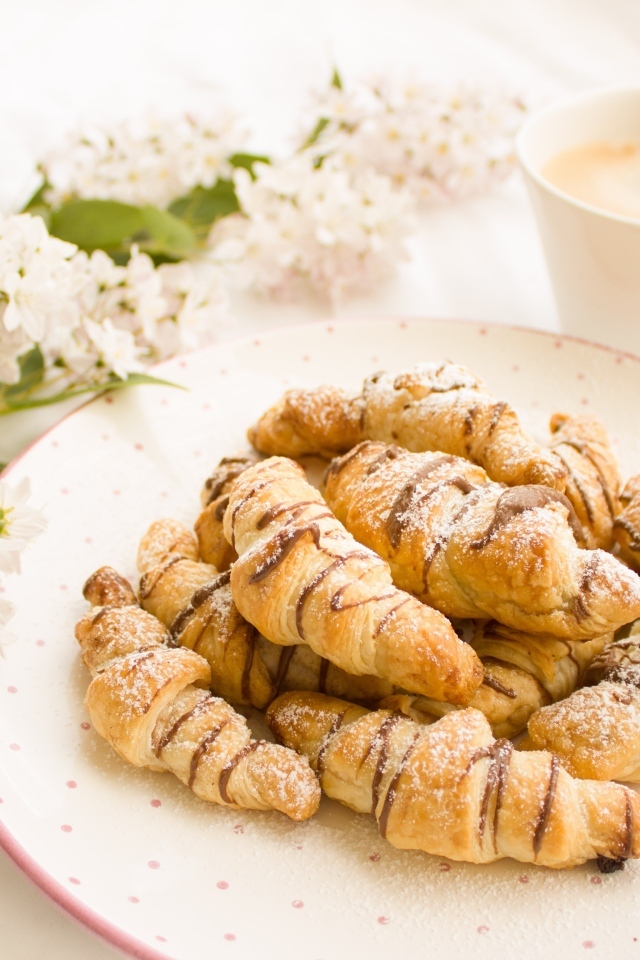 Круассаны на столе с кофе и цветами