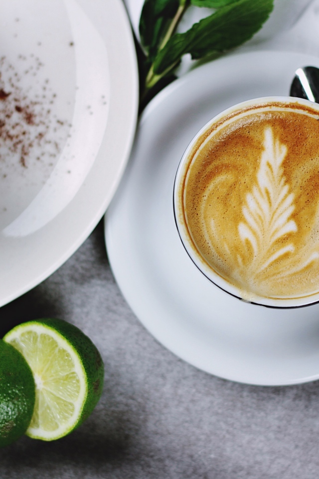 Чашка кофе на столе с пирожным и лаймом