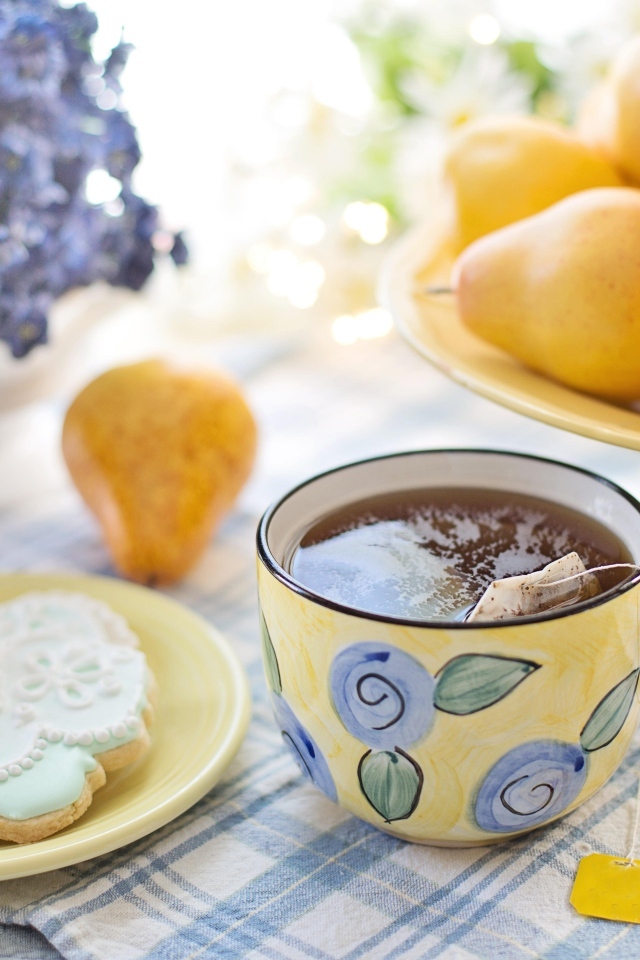 Чашка чая на столе с грушами и печеньем