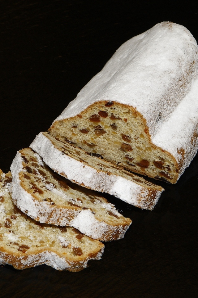 Кекс с изюмом и сахарной пудрой на черном фоне