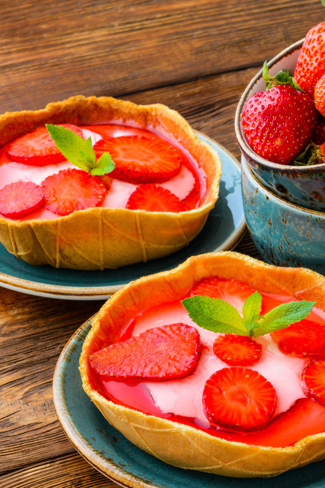 Вкусные пирожные с ягодами клубники на тарелке