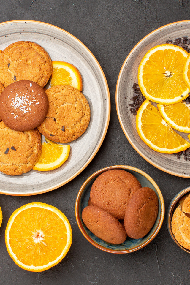 Вкусное печенье на тарелке с апельсинами