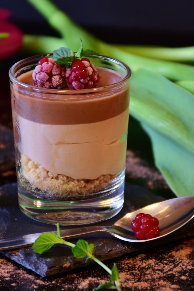 Десерт в стакане на столе с тюльпаном