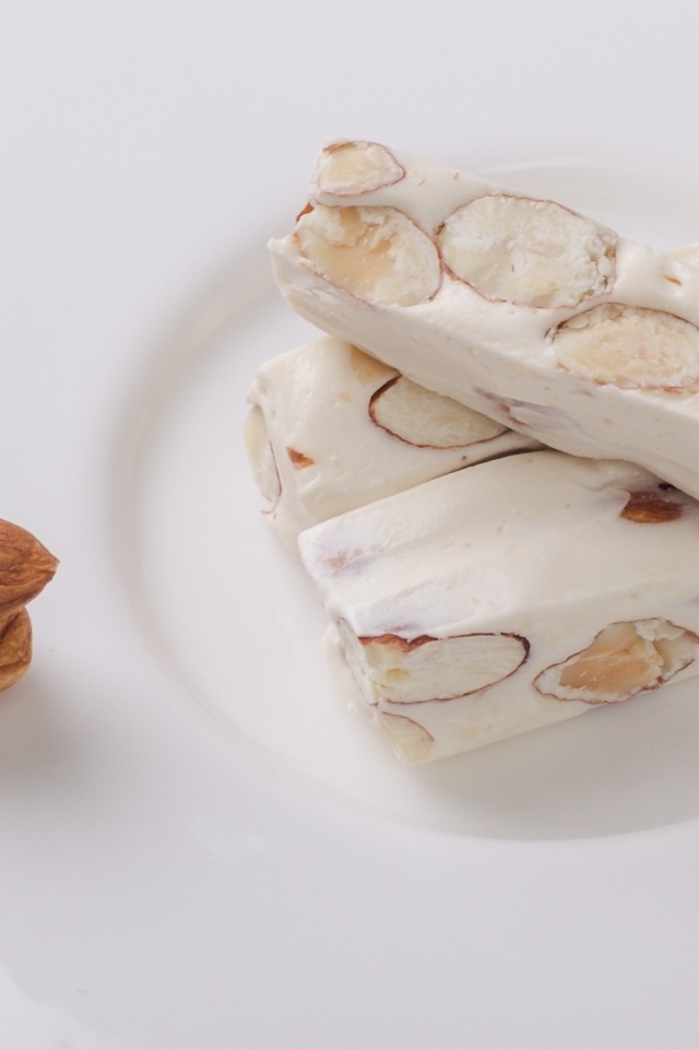 Десерт нуга с миндальными орехами на тарелке 