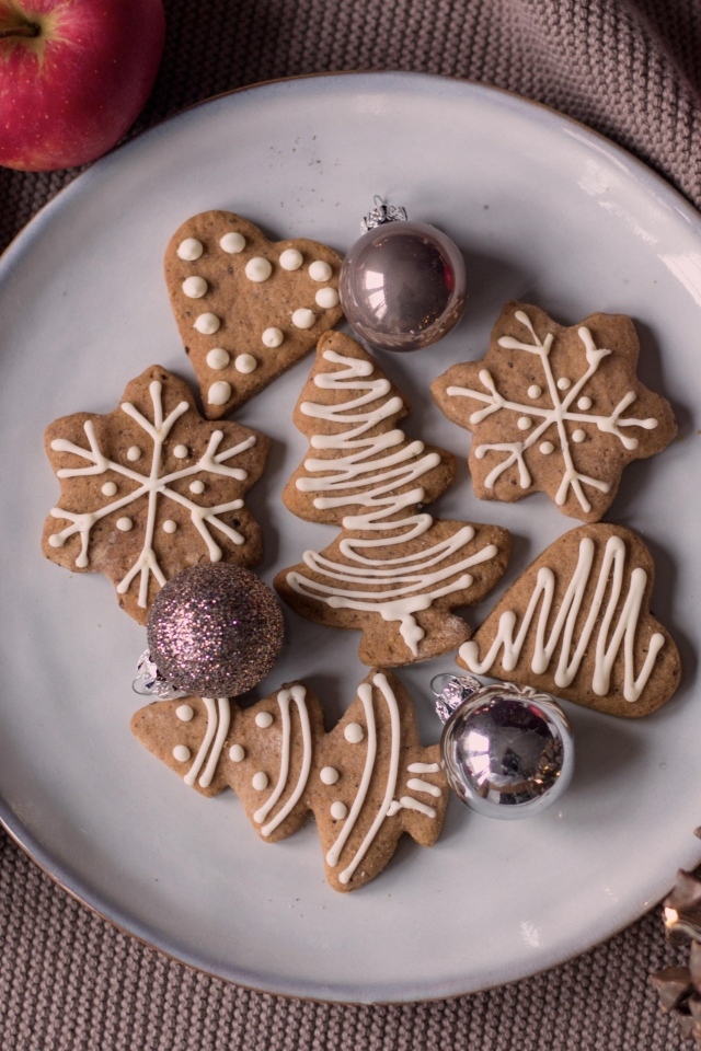Праздничное печенье на столе с яблоками и шишками