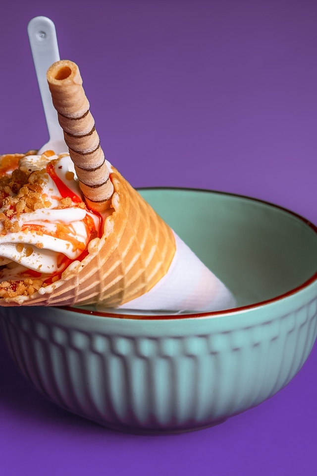 Мороженое рожок с трубочкой на фиолетовом фоне