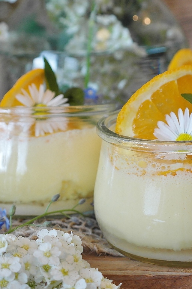 Лимонный крем в стеклянных банках на столе с цветами