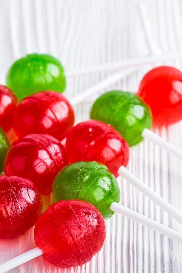 Разноцветные леденцы на палочке лежат на столе