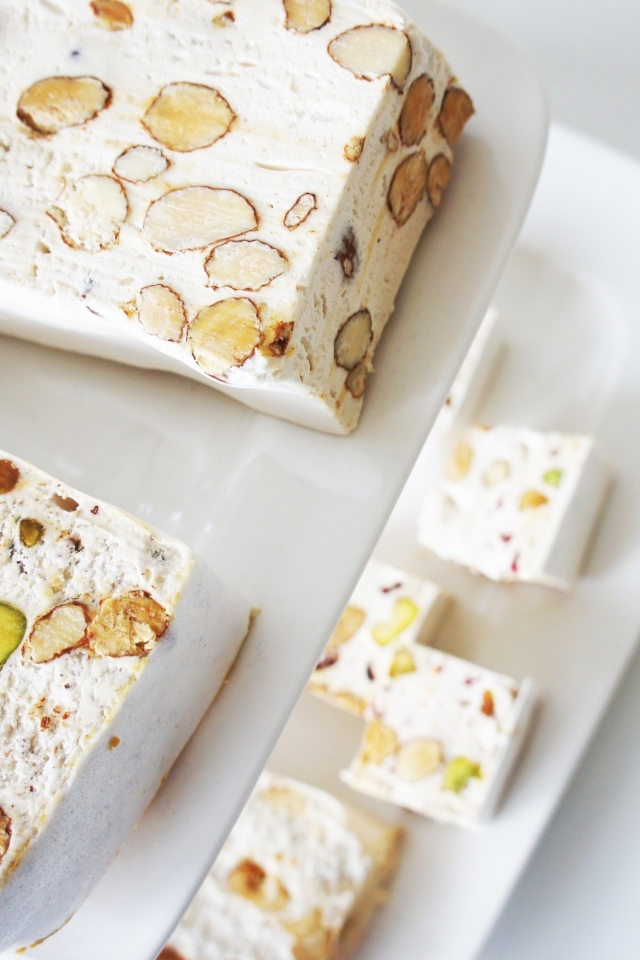 Нуга с орехами на белой тарелке