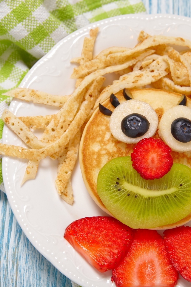 Блины с ягодами на тарелке для ребенка