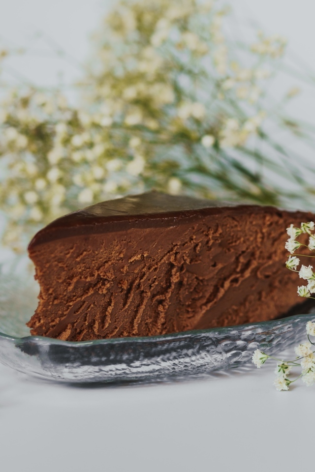 Кусок шоколадного пирога с белыми цветами гипсофилы