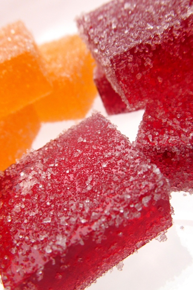 Куски сладкого ягодного мармелада на белом фоне