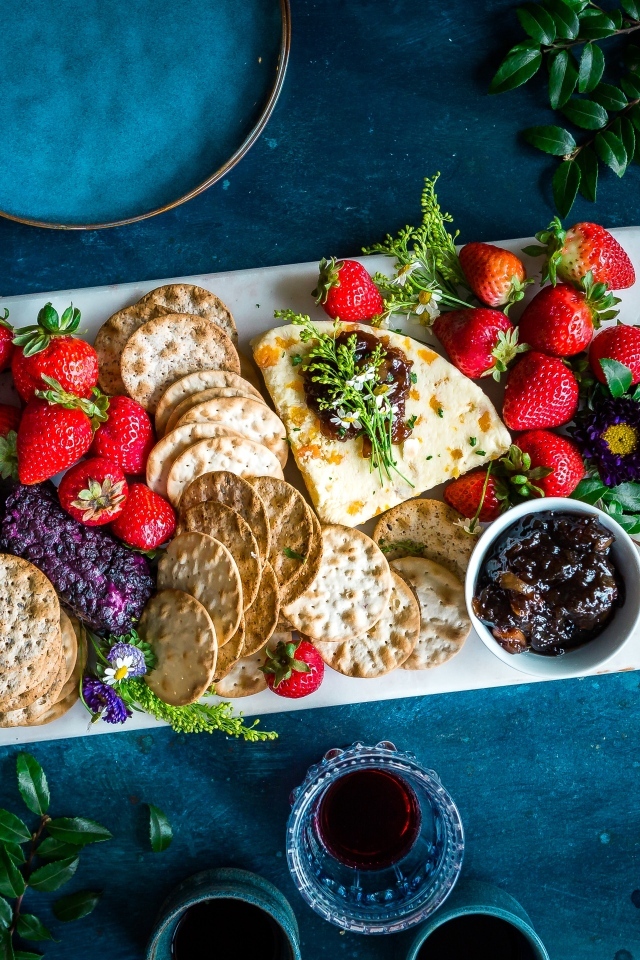 Тарелка с печеньем, сыром и ягодами клубники