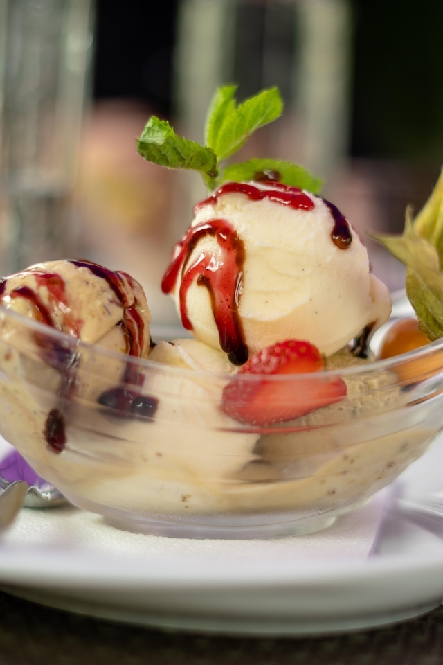 Шарики фруктового мороженого в стеклянной пиале на столе