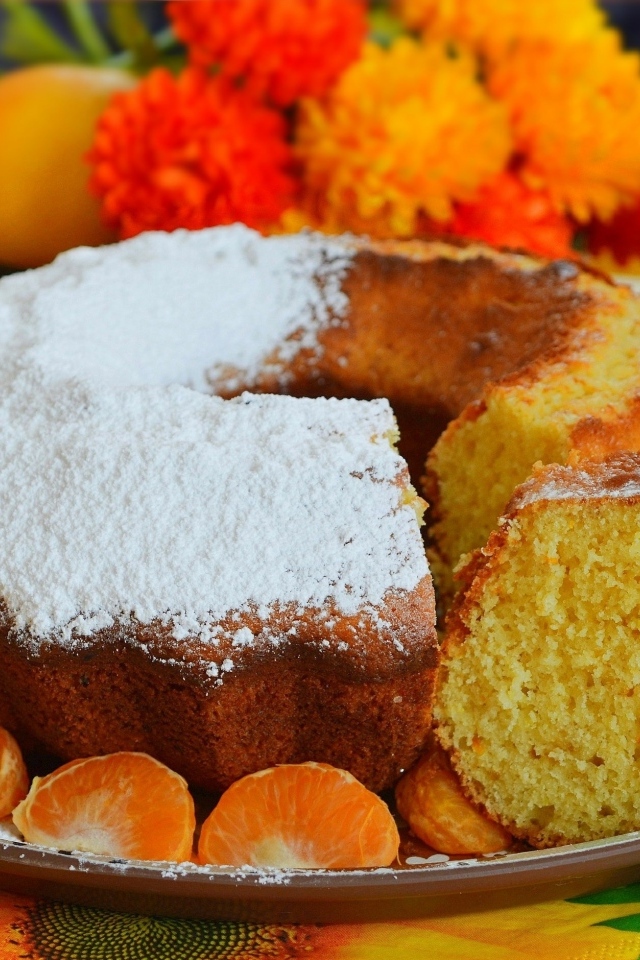 Сладкий пирог на столе с мандаринами и апельсинами
