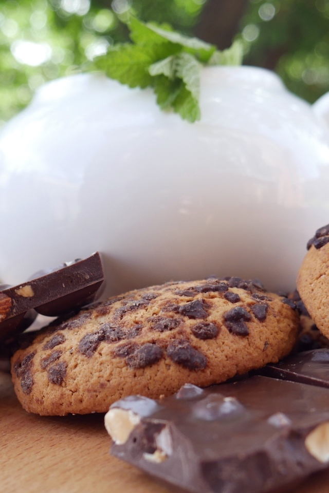 Чайник на столе с печеньем и шоколадом