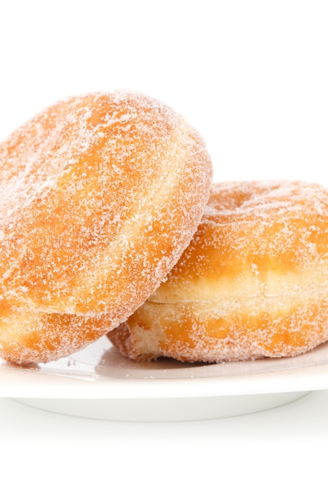 Два сладких пончика в сахарной пудре на белом фоне