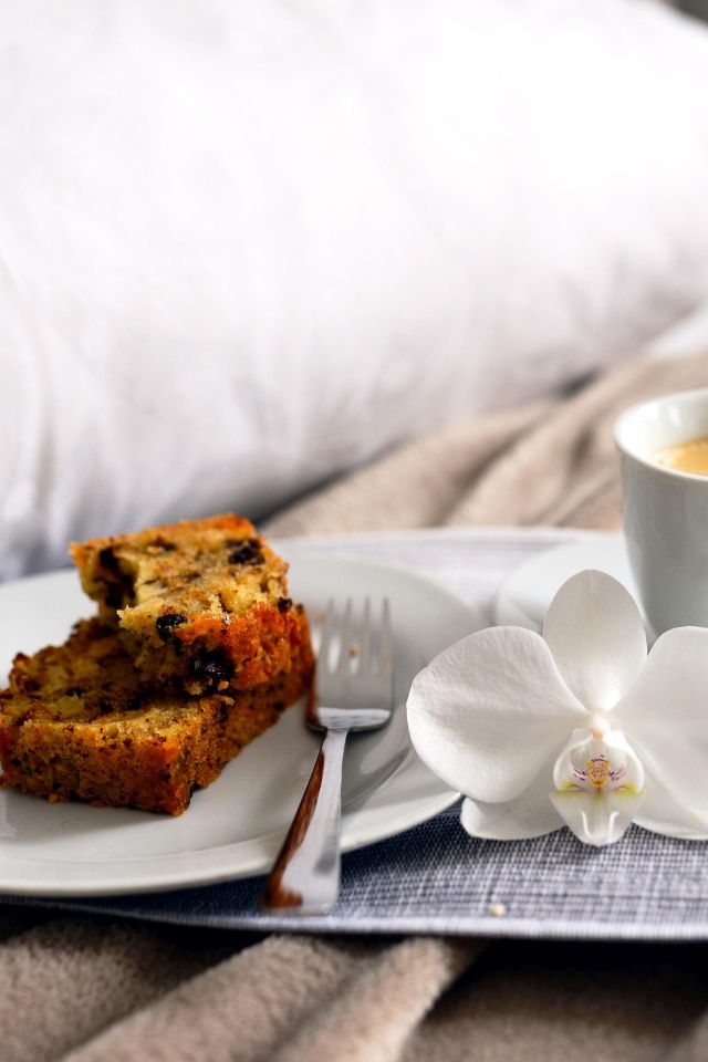 Чашка кофе с цветком орхидеи и кусочками кекса