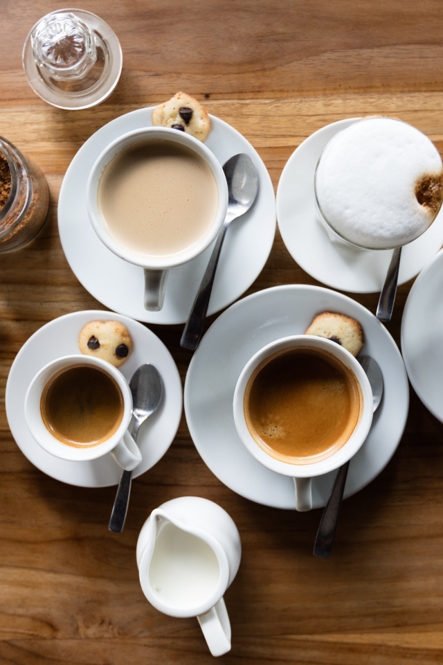 Чашки с кофе на столе с сахаром и молоком