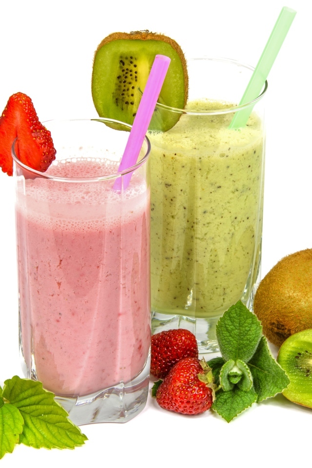 Фруктовые коктейли в стаканах на столе с клубникой и киви