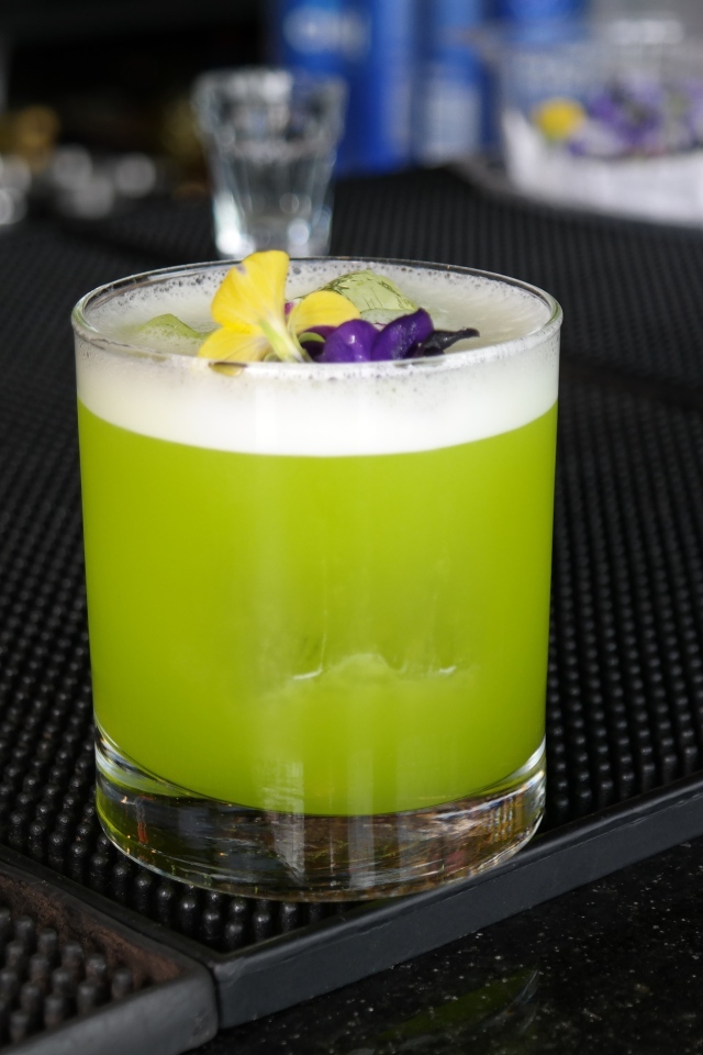 Зеленый коктейль в стакане с цветами