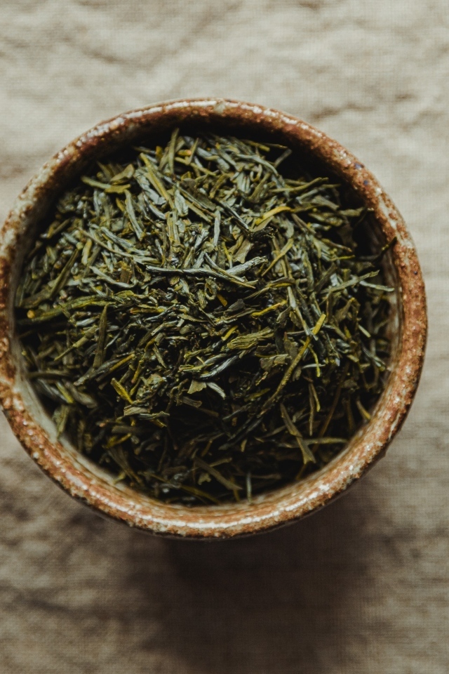 Зеленый чай в пиале на столе с чайником