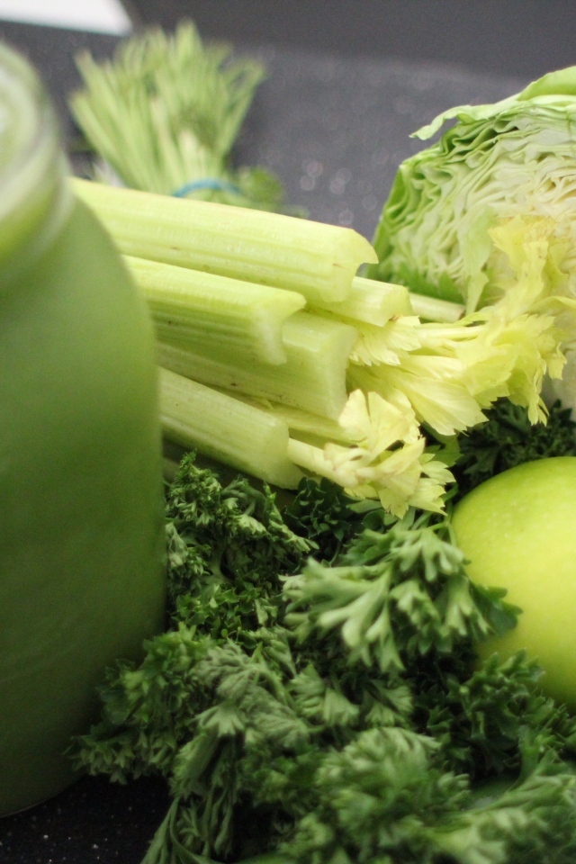 Полезное зеленое смузи на столе с овощами  и зеленью 