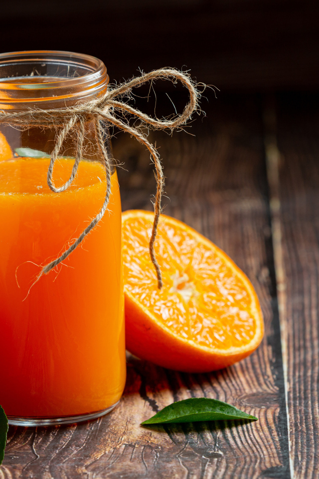 Банка свежего сока на столе с мандаринами