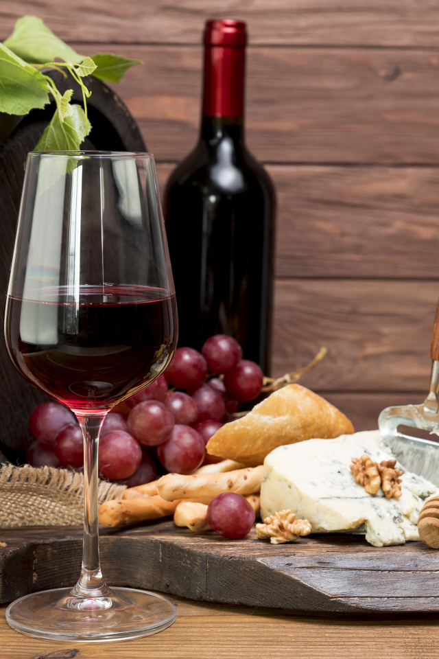 Красное вино с сыром и орехами на столе
