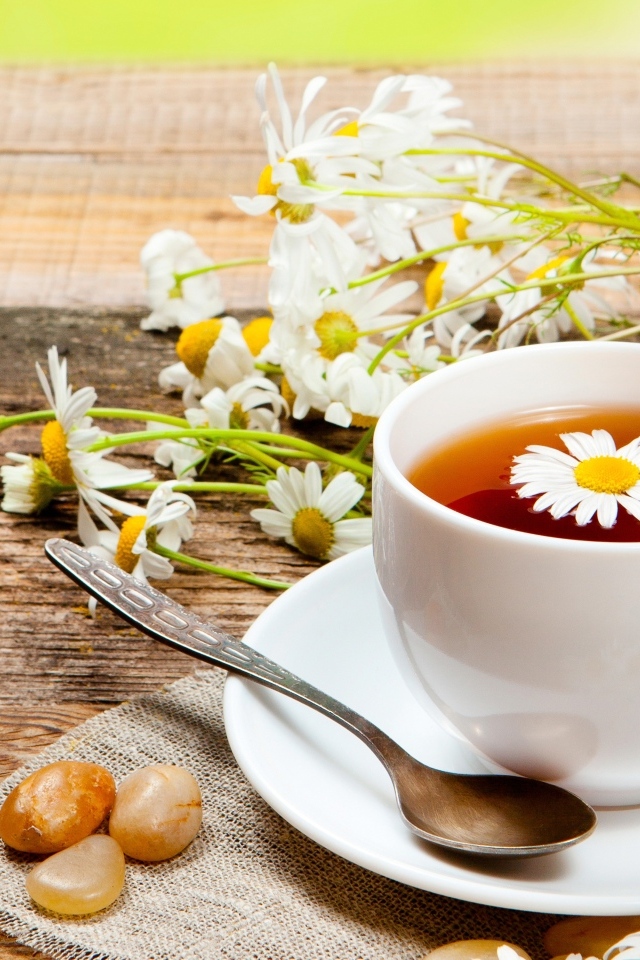 Чай на столе с цветами ромашки и конфетами