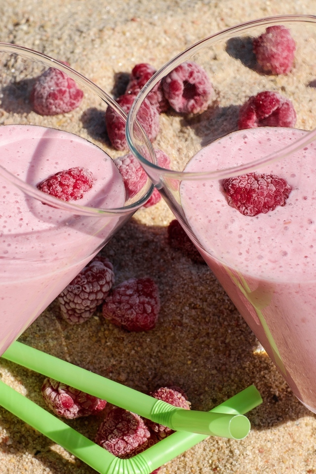 Два стакана ягодного смузи с малиной на песке 