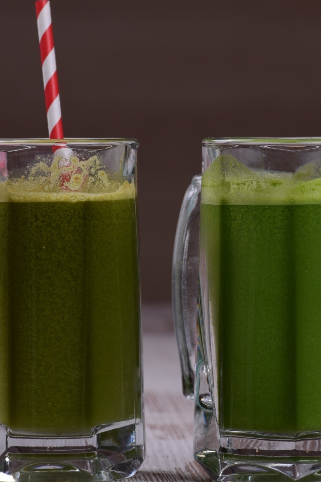 Два стакана зеленого смузи с трубочками