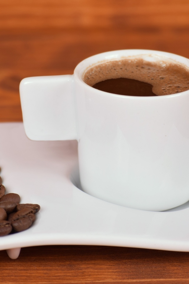 Белая чашка горячего кофе на столе 