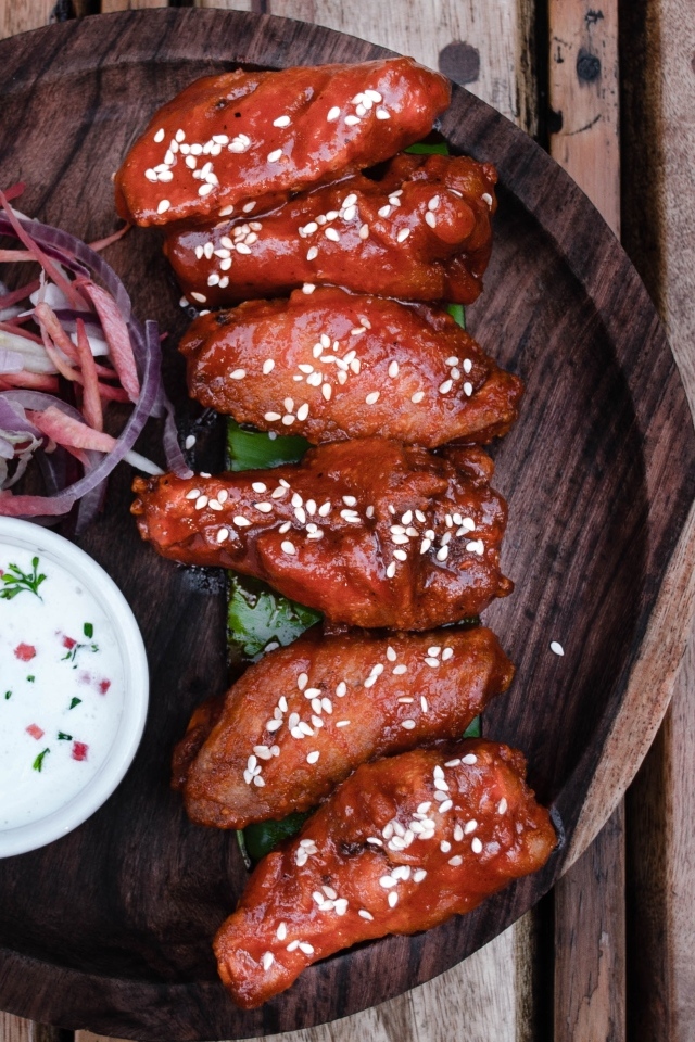 Запеченные куриные крылышки с соусом на тарелке