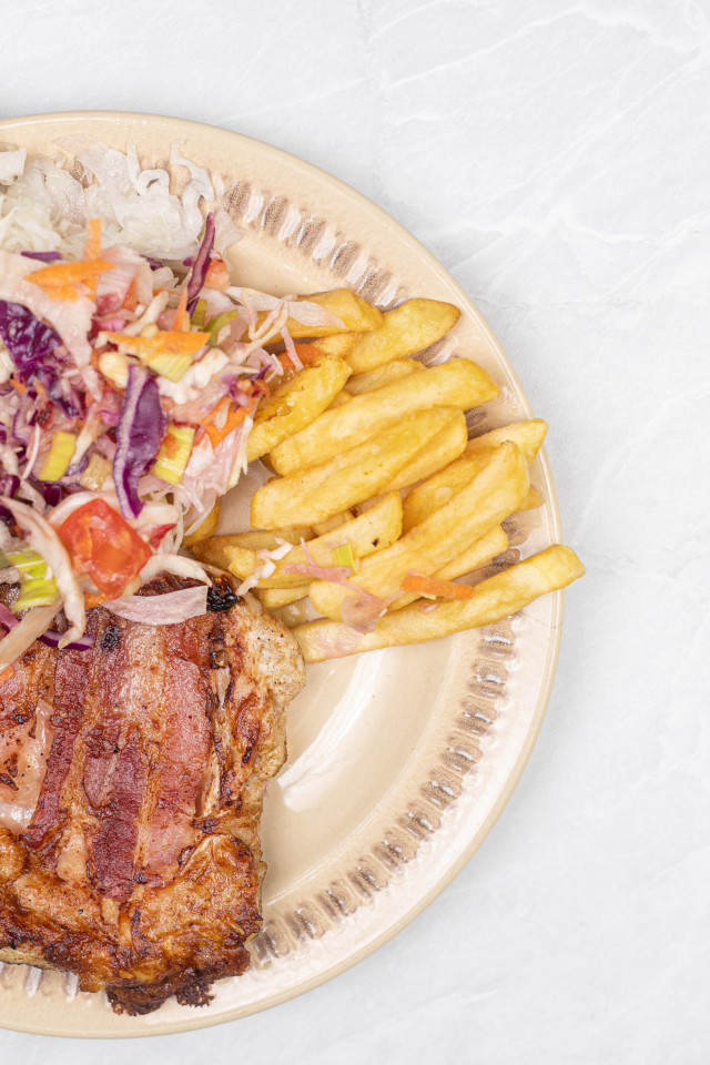 Meat on a plate with french fries and salad