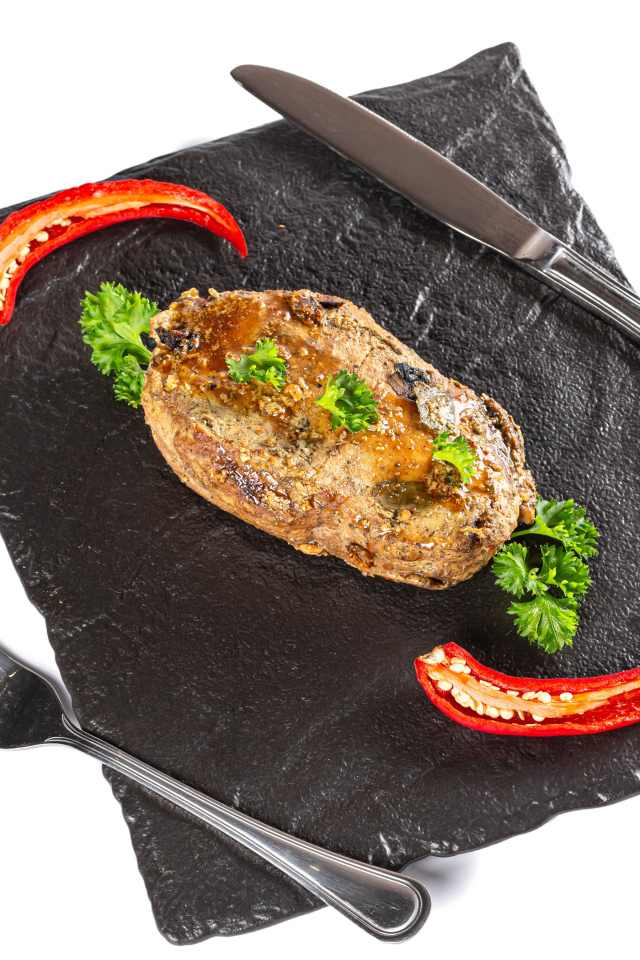 Кусок мяса с красным перцем на доске